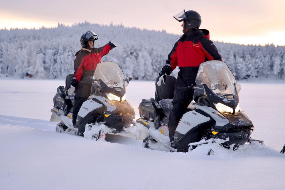 Turistit nauttivat aurinkoisesta ja lumisesta Lapin kevätpäivästä moottorikelkkasafarilla