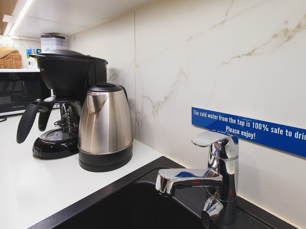 Puhtaan keittiön työtasolla on mikroaaltouuni sekä kahvin- ja vedenkeitin.