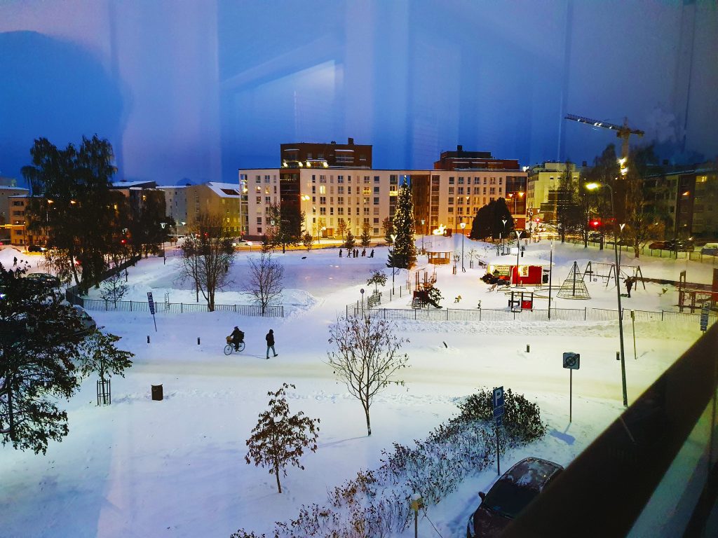 Talvinen iltanäkymä asunnon parvekkeelta jouluisaan puistoon Rovaniemen keskustassa.