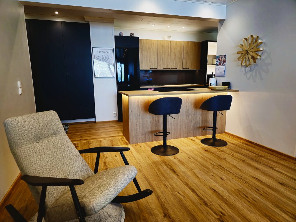 Nykyaikaisen kaupunkiasunnon ledivalaistu ateriointi- ja keittiötila.